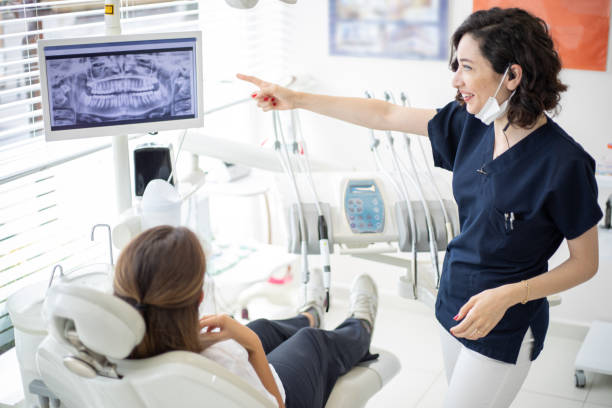 istock Female dentist talking to her patient at dentist's office 1035417856