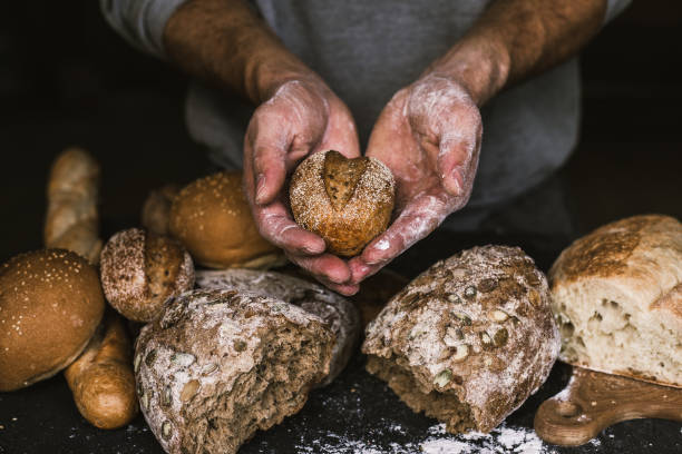 istock Baker man holding a rustic organic loaf of bread in his hands 1035417886