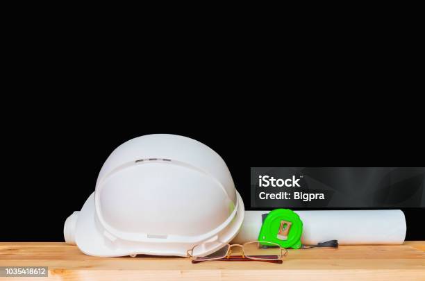 Helmet Plastic White With Glasses Paper Roll Plan Blueprint And Measuring Tape Green Hat Safety Equipment Working Of Engineering Concept Construction On Wooden Floor Isolated Black Background Clipping Path Stock Photo - Download Image Now