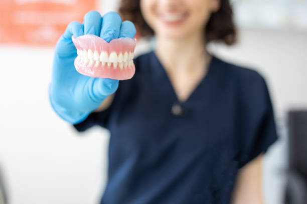 zahnarzt hält zahnbein - künstliches gebiss fotos stock-fotos und bilder