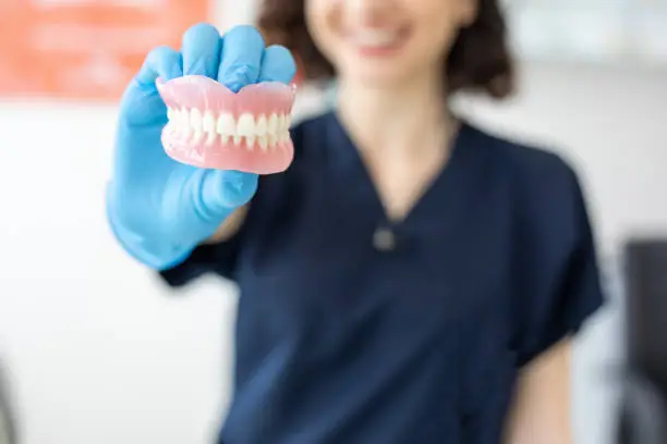 Photo of Dentist holding denture