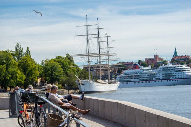 Stockholm, Sweden, 8/6/2013, People sitting on the bench, ships in the harbor. Stockholm. Parked bikes.