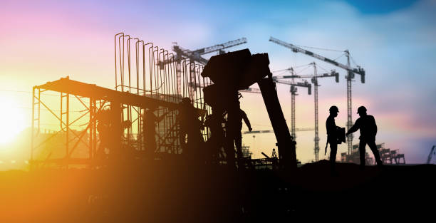 istock Silhouette of engineer and construction team working at site over blurred background for industry background with Light fair.Create from multiple reference images together. 1035456306