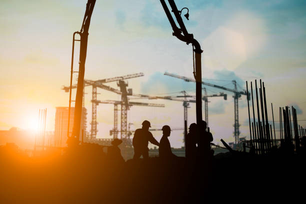 istock Silhouette of engineer and construction team working at site over blurred background for industry background with Light fair.Create from multiple reference images together. 1035456310