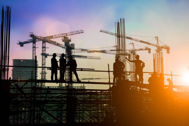 istock Silhouette of engineer and construction team working at site over blurred background for industry background with Light fair.Create from multiple reference images together. 1035456320