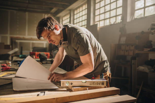 istock Focused carpenter going through new business project in a workshop. 1035457870