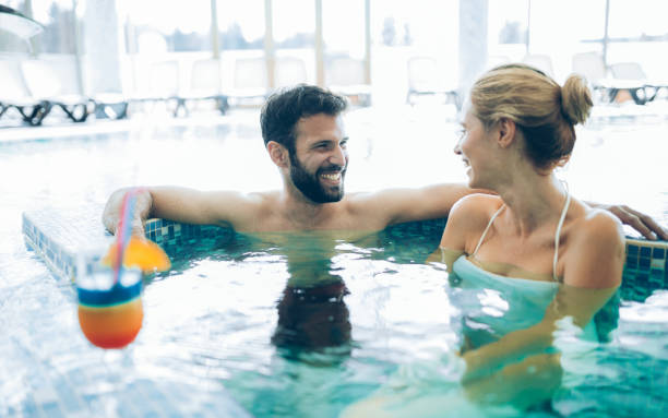 istock Happy attractive couple relaxing in swimming pool 1035471946