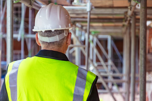 widok z tyłu mężczyzn budowniczego budowniczego na placu budowy w twardym kapeluszu i kamizelce hi vis - white hardhat zdjęcia i obrazy z banku zdjęć