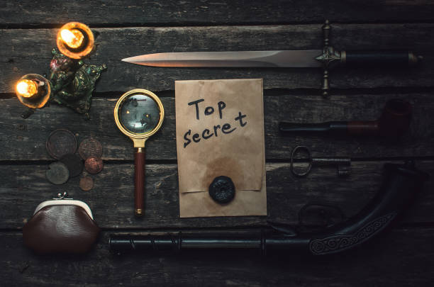 Detective table. Top secret documents file, musket gun, dagger, magnifying glass, smoking pipe, and wallet with coins on the detective spy agent. wallet gun stock pictures, royalty-free photos & images