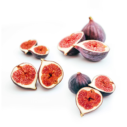 A set of ripe blue figs, whole, cut and sliced, isolated on white background. Healthy dieting concept.