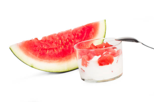 A glass of yogurt with pieces of watermelon
