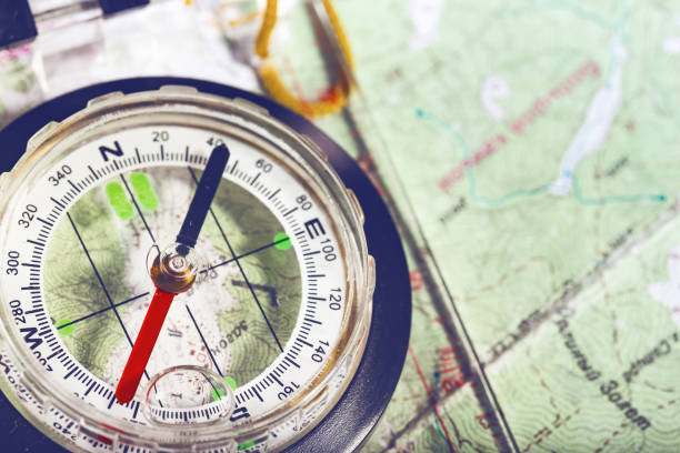 retro-stil abstrakt schießen mit dem kompass auf einer karte - orienteering stock-fotos und bilder