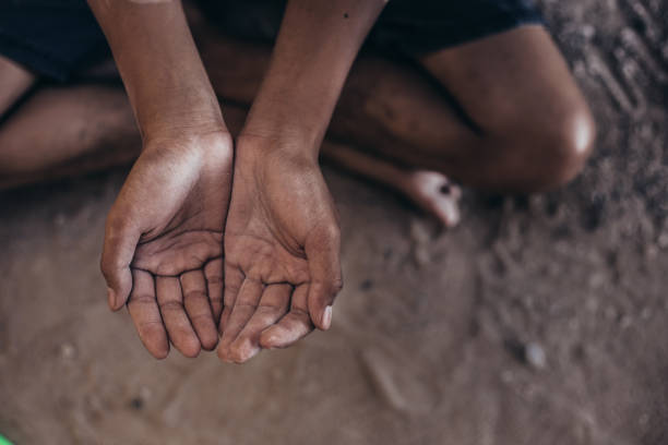 hands of hunger child hands poor child or beggar begging you for help sitting at dirty slum. concept for poverty or hunger people,human rights,donate and charity for underprivileged children in third world alms stock pictures, royalty-free photos & images