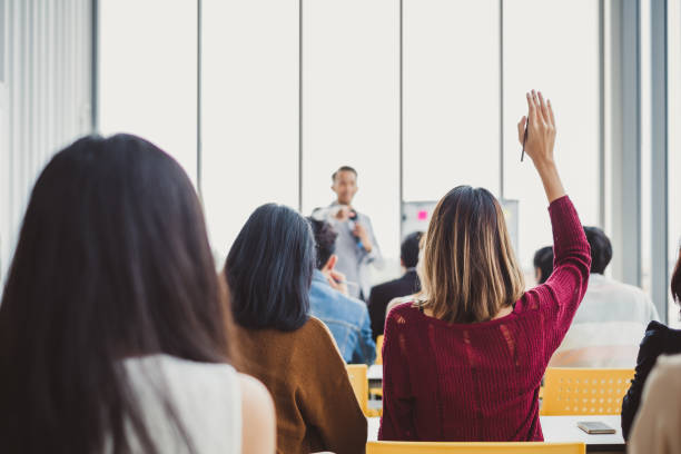 back view business woman raising hand for asking speaker for question and answer concept in meeting room for seminar - question mark audio imagens e fotografias de stock