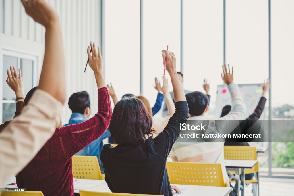 Group of business people raise hands up to agree with speaker in the meeting room seminar Education Training Class Stock Photo