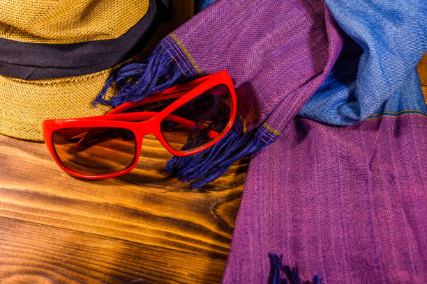 istock Scarf, straw hat and eyeglasses on wooden table 1035508594