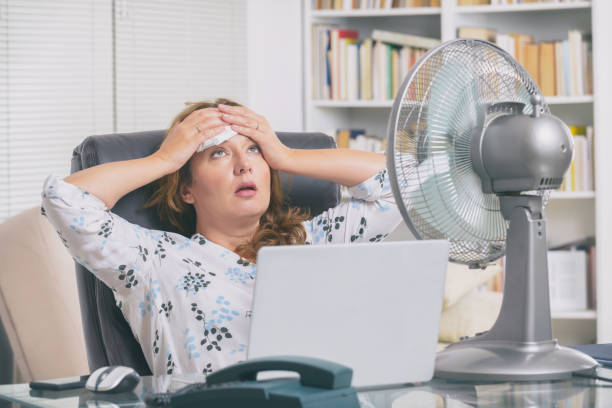 Woman suffers from heat in the office or at home stock photo
