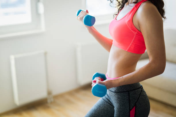 istock Young attractive sportswoman doing exercises at home 1035512050