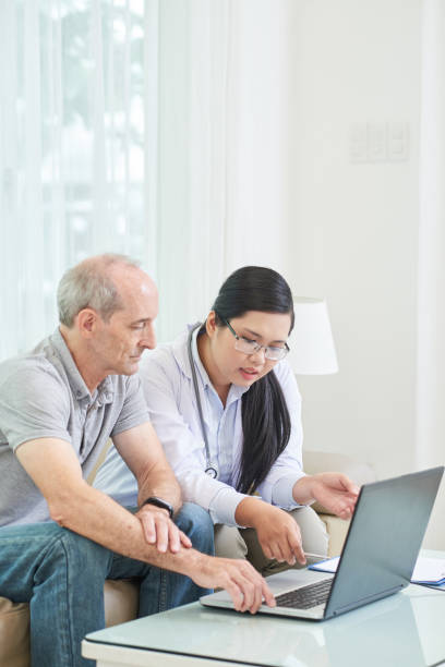istock Senior patient with woman watching laptop 1035512706