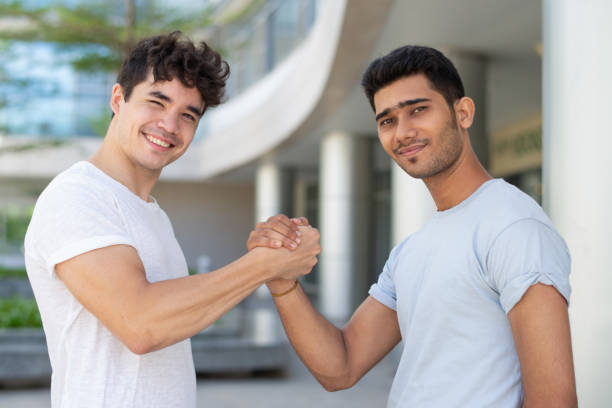 Portrait of happy multiethnic students greeting with handshake