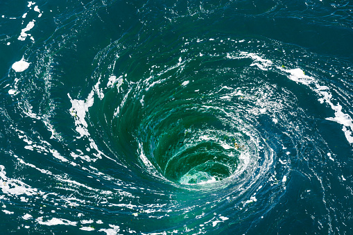 A powerful whirlpool is generated at the surface of the green waters of the river Rance by the action of a turbine of the tidal power station near Saint-Malo in Brittany, France.