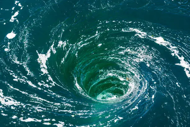 Photo of A powerful whirlpool is generated at the surface of the green waters of the river Rance by the action of a turbine of the tidal power station near Saint-Malo in Brittany, France.