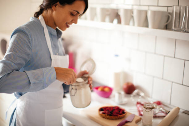 istock Woman preparing white cake with blueberries on top 1035522734