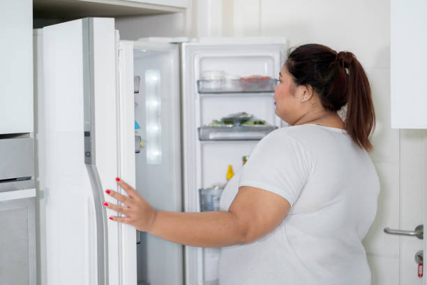 istock Overweight woman opening a fridge 1035526334