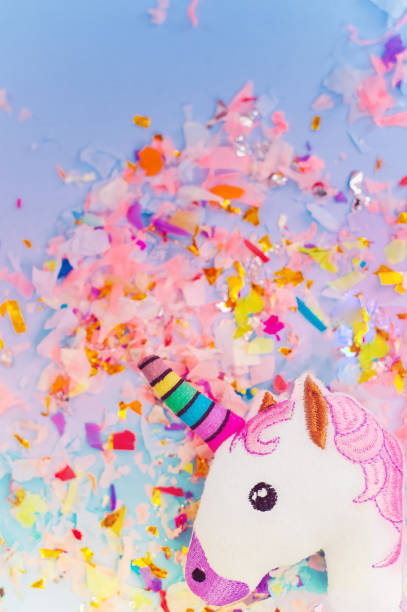 istock A white unicorn with rainbow horn and confetti top view. 1035527300