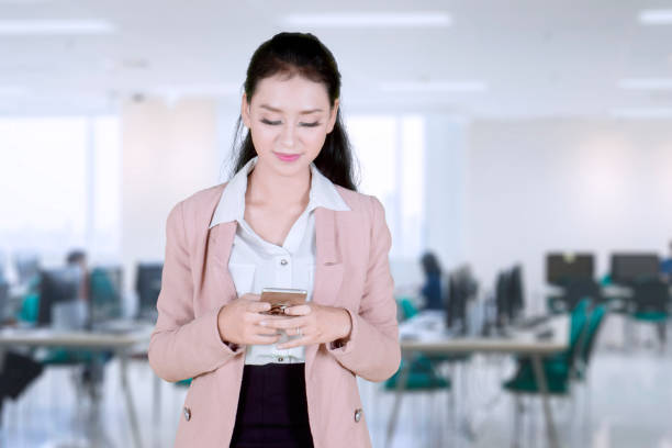 istock Beautiful Asian businesswoman sending text message at office 1035535762