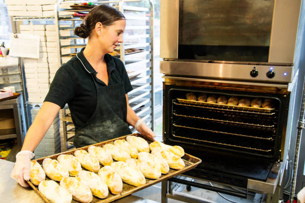 istock A female baker putting buns in an oven 1035541128