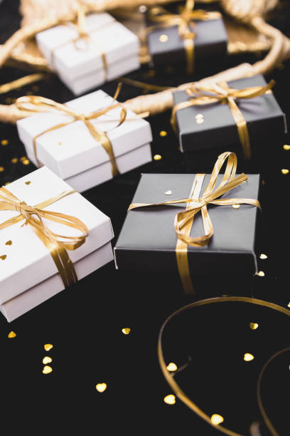 istock Black and white gift boxes with gold ribbon on shine background. 1035544016