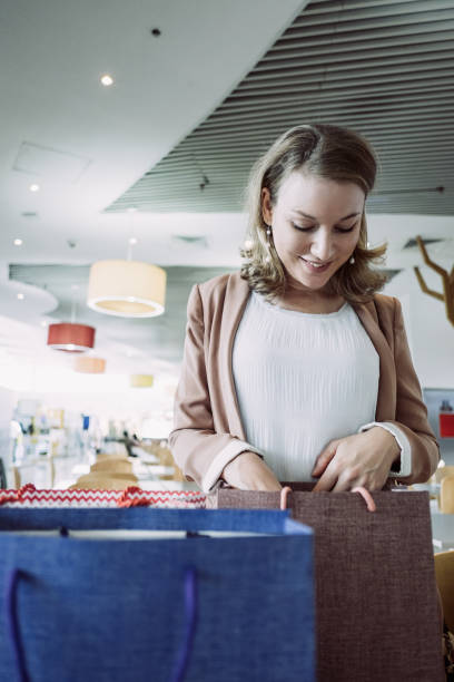 istock Smiling Lady with Bags on Table in Shopping Mall 1035549268