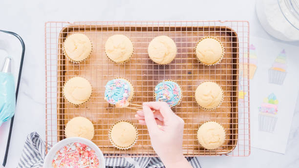 istock Decorating unicorn themed vanilla cupcakes with rainbow buttercream frosting. 1035549512