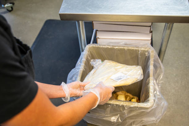 istock Employee in a supermarket bakery throwing out waste 1035549818