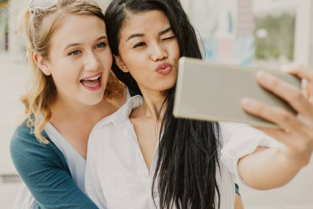 istock Two Beautiful Diverse Women Making Selfie Photo 1035550826