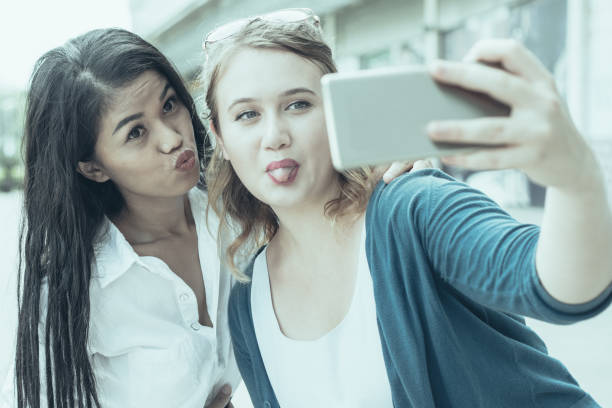 istock Two Women Making Faces and Taking Selfie Photo 1035550998