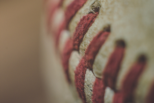A close up shot of the details of a baseball.