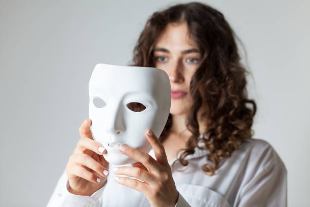 istock Young Woman Holding Mask Against White Background 1035574906