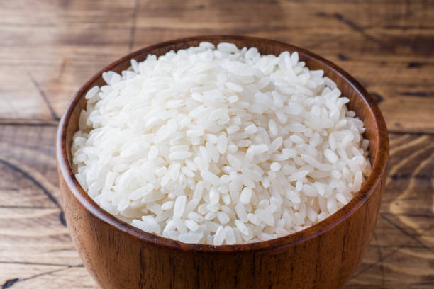 istock White rice grits in wooden bowl on rustic wooden background. 1035575720