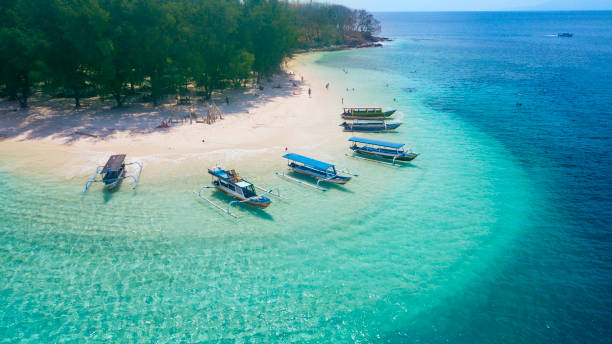 turismo barcos anclan en la playa de gili rengit - indonesia fotografías e imágenes de stock