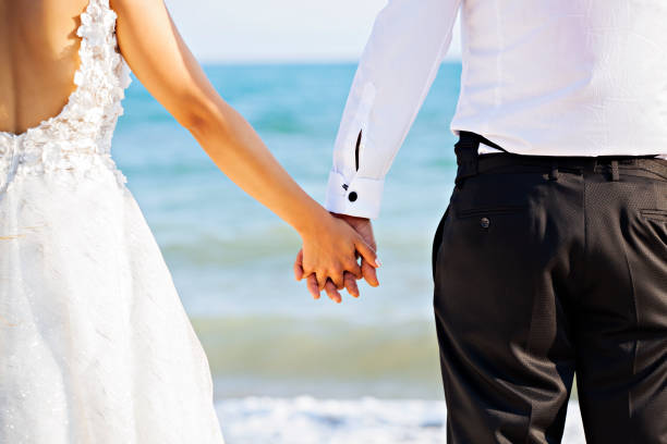 istock Wedding couple holding hands on the beach 1035590974