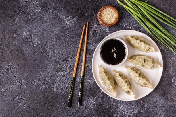 Asian dumplings, soy sauce, chopsticks. Top view, copy space.