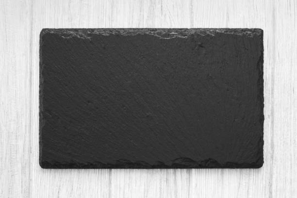 istock White painted wooden table background with natural shale stone plate 1035599964