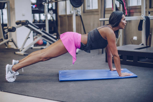 istock Woman doing push-ups in gym 1035600898