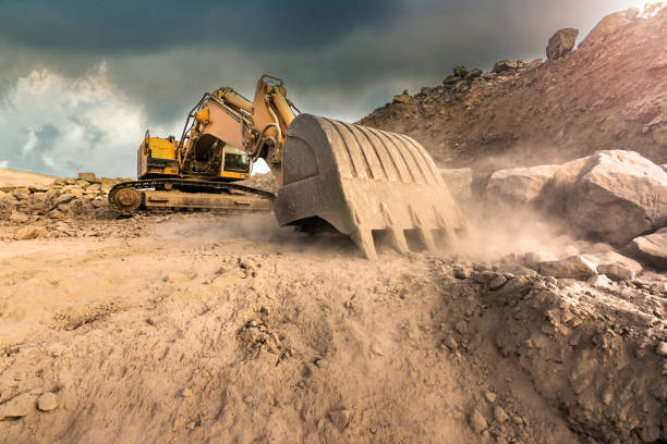 istock Large excavator extracting stone in a dust cloud in a desert 1035603096
