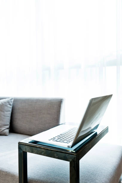 istock Laptop on table near gray sofa 1035603656