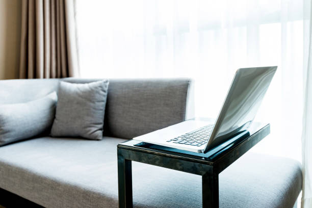 istock Laptop on table near gray sofa 1035603696