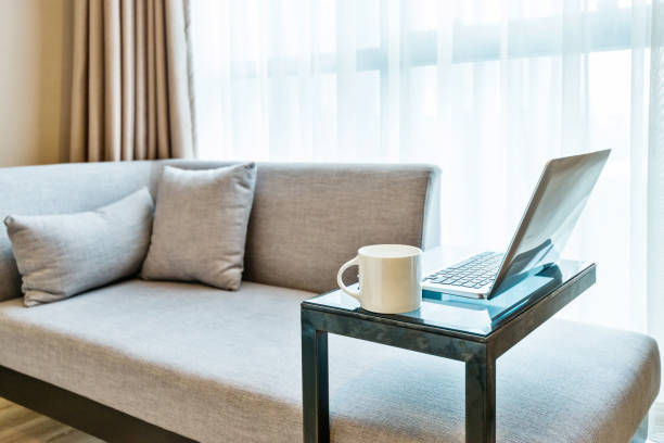 istock Laptop on table near gray sofa 1035603776
