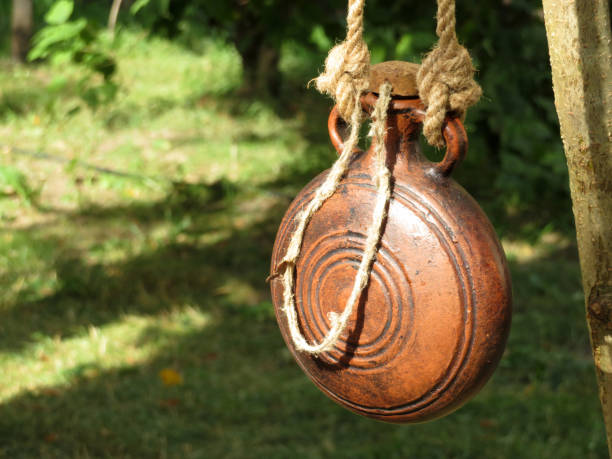 istock Ancient clay flask hanging on a rope on the background of the forest 1035604122
